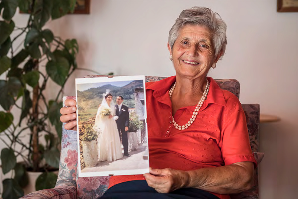 Stella Scutari holds a photograph of herself on the day of her wedding, 1957